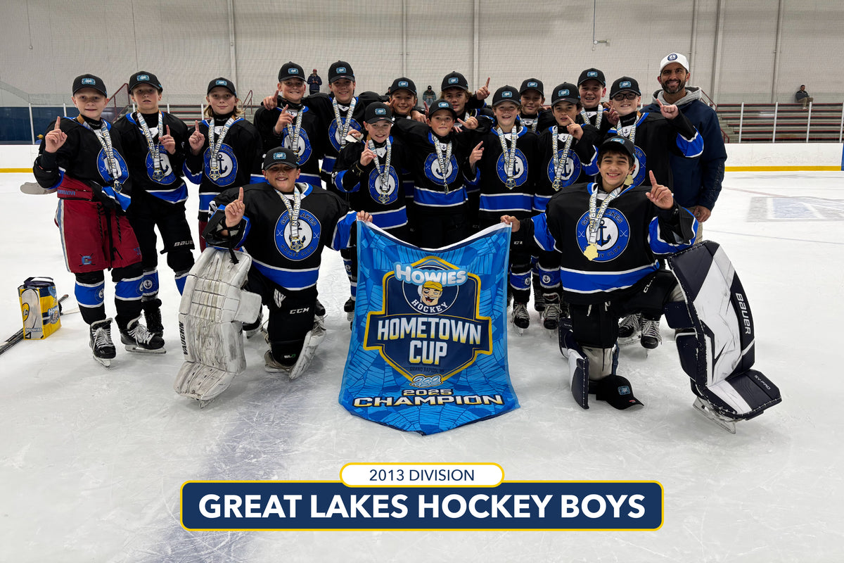 Hockey team celebrating with a championship banner on an ice rink