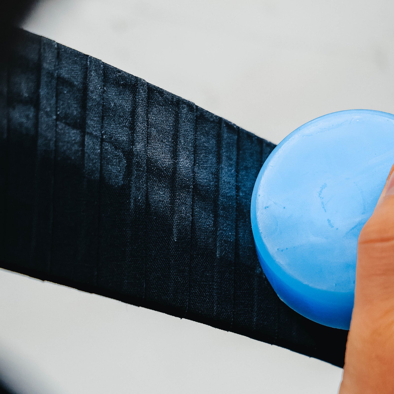 Hockey player waxing the blade of his stick 