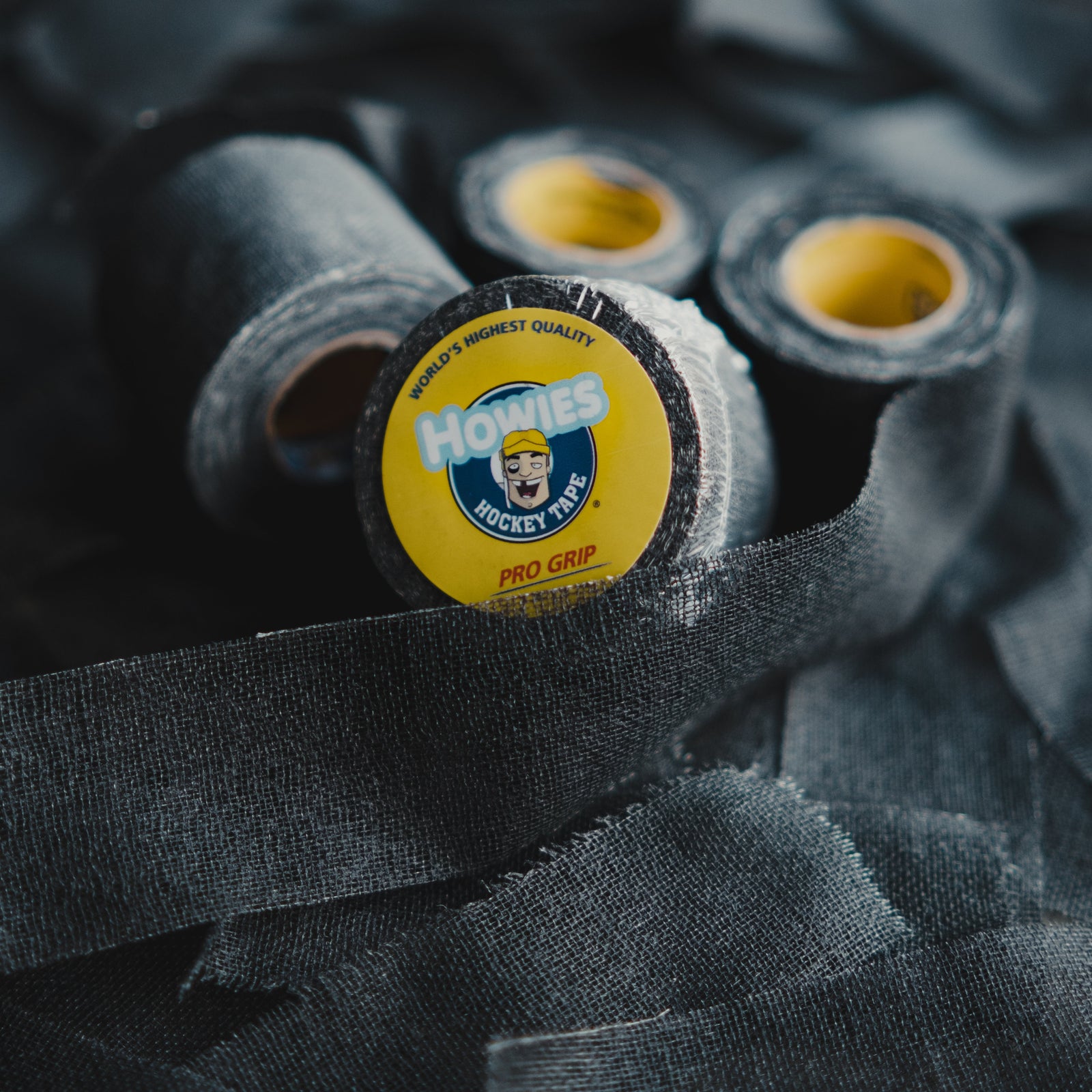 Three rolls of Howies Pro Model hockey tape on a textured dark surface.