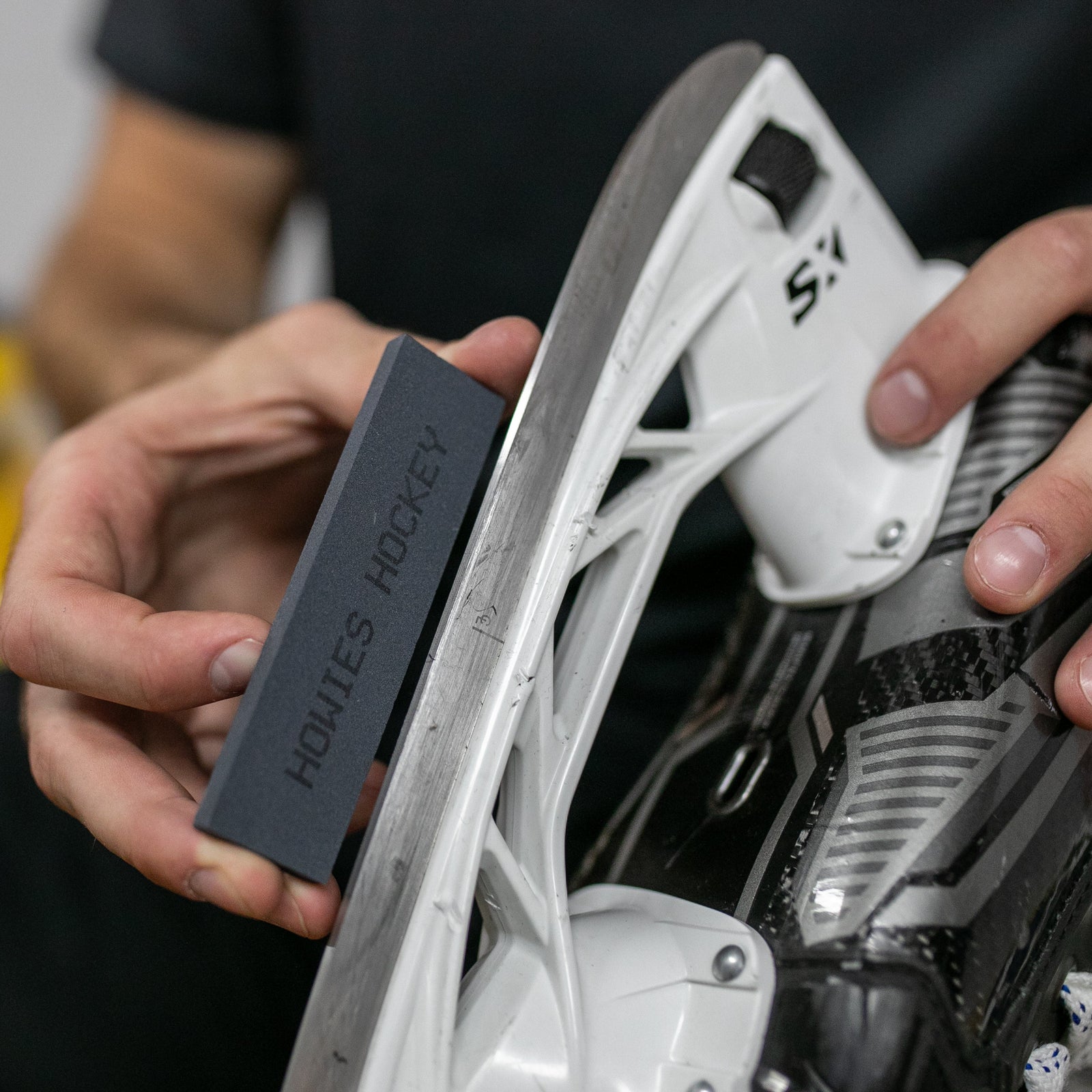 Person using a stone on a skate blade 