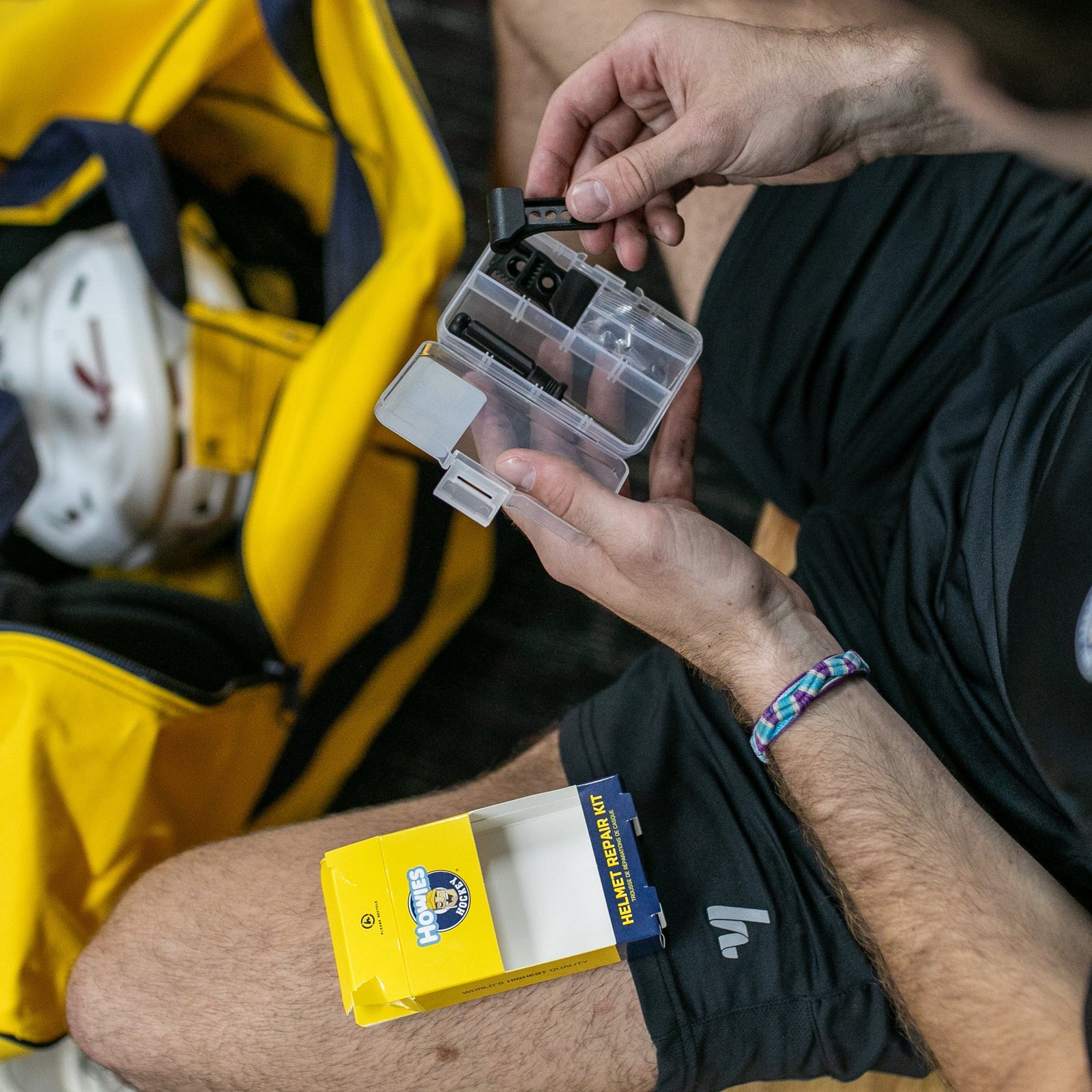 Person opening plastic case with screws and screwdriver inside of it 