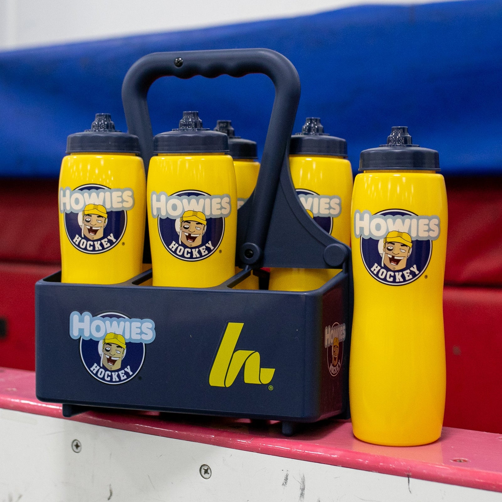 Yellow water bottles in a carrier with a howies logo on it 