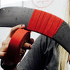 Person holding a hockey stick with red tape 