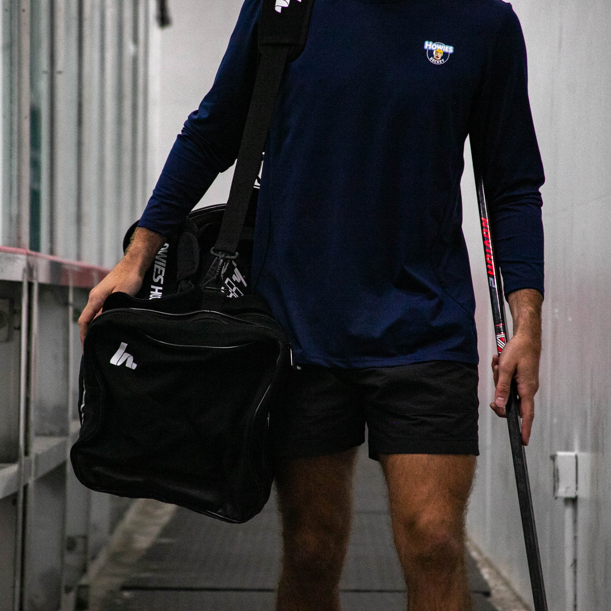 Person holding a black bag and walking in an industrial setting