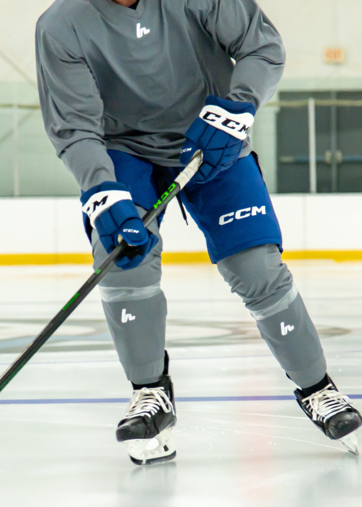 Person on an ice rink wearing hockey gear with visible brand logos.