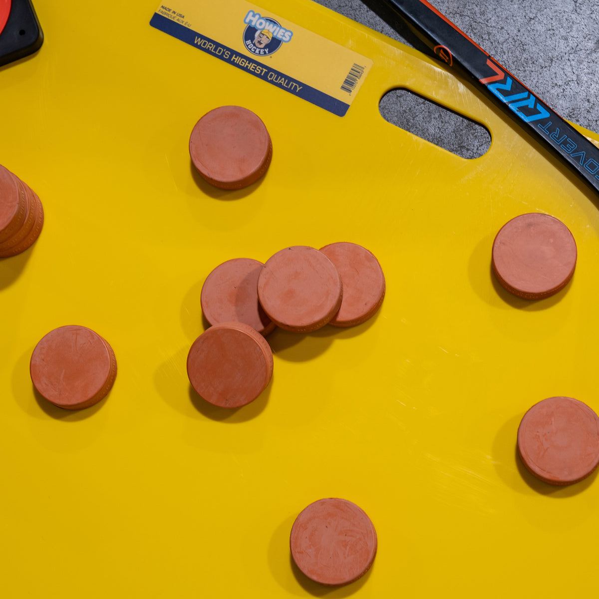 Orange pucks on a yellow shooting pad
