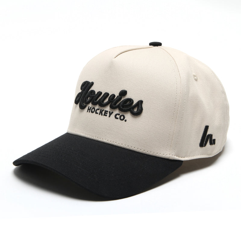 The Clean Sheet Lid by Howies Hockey Co. – cream and black snapback hat with raised black Howies script logo on the front