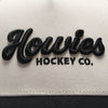 Close-up of the raised black embroidered Howies Hockey Co. script logo on the cream front panel of the Clean Sheet Lid