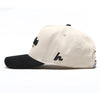 Side profile of the Clean Sheet Lid showing the cream crown, black brim and embroidered Howies "h" side logo