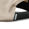 Back of the Clean Sheet Lid showing the black snapback strap with a woven blue and white Howies tag